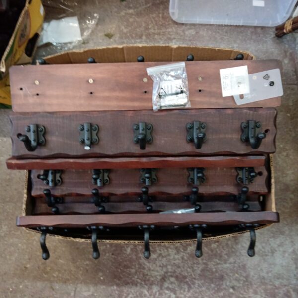 Dark wood rustic coat rack with five hooks.