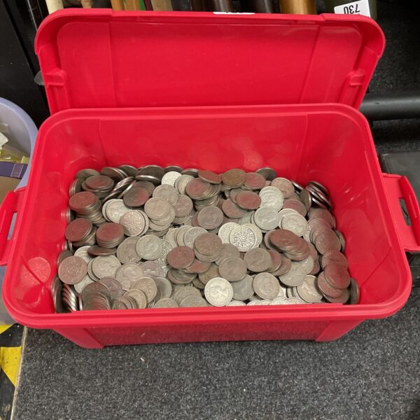 Red box filled with a large lot of British shilling coins.