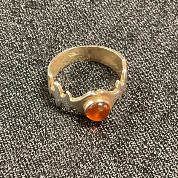 Close-up of a silver ring with amber gemstone.