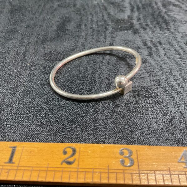 Minimalist silver bracelet with ball and cube ends.