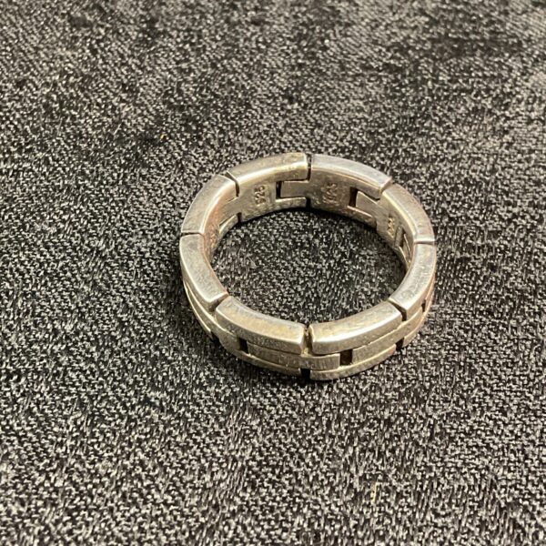 Close-up of a silver hinged brick link ring.