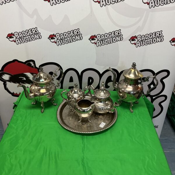 Ornate silverplate tea and coffee set on a display surface.