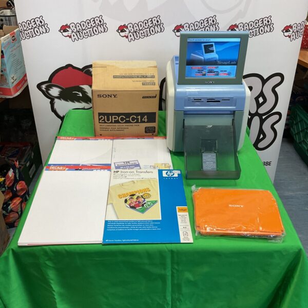 Sony SnapLab photo printer with accessories on a green table.