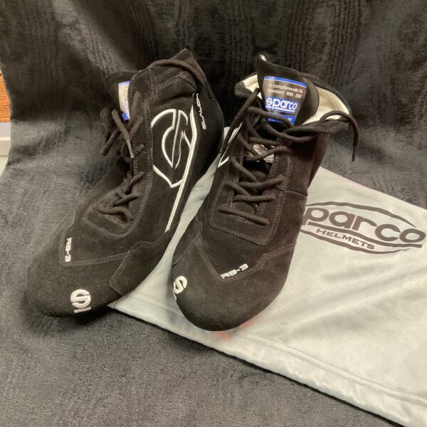 Pair of black and white Sparco race boots on a grey surface.