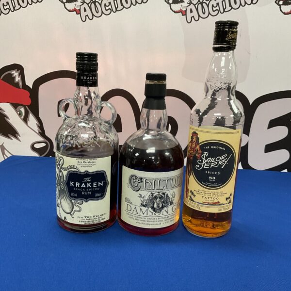 Opened bottles of Kraken, Chilton, and Sailor Jerry spiced rum and gin.