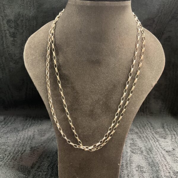 Delicate sterling silver chain necklaces set on display.