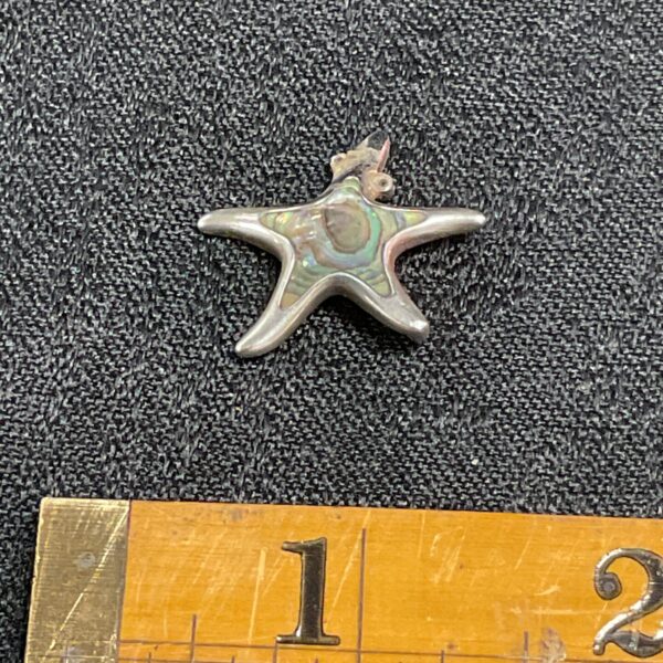 Close-up of sterling silver starfish pendant with mother of pearl.