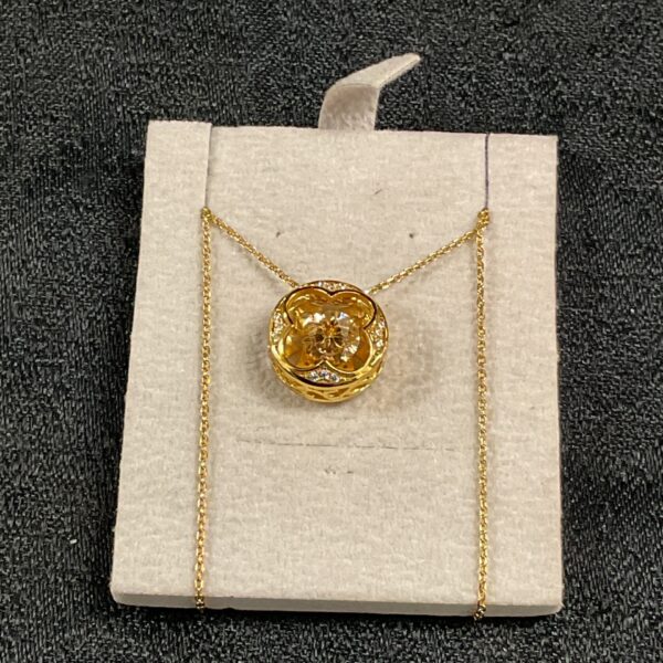 Close-up of a Swarovski gilt pendant necklace with shimmer stone.