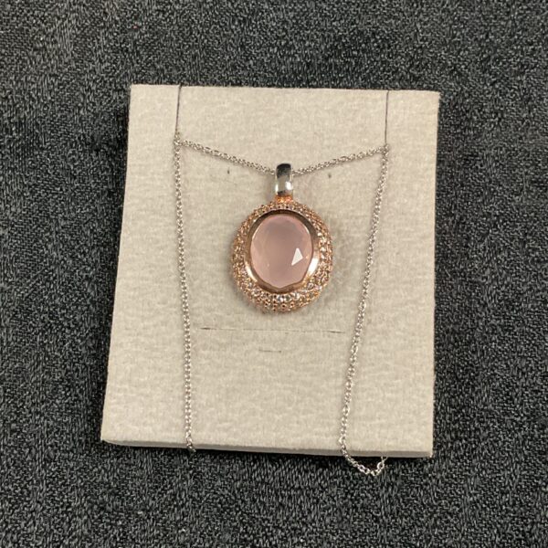Close-up of a Swarovski pink crystal pendant necklace with gilt details.
