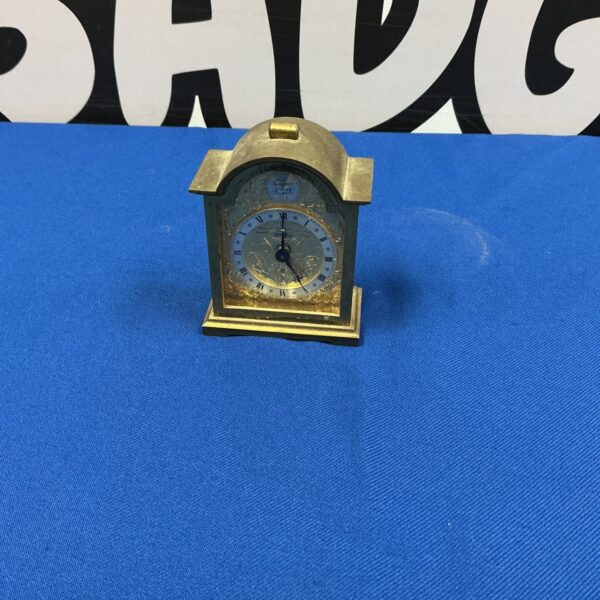 Antique Swiss made brass mantle clock with Roman numerals.