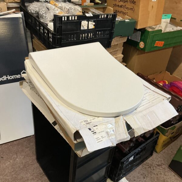 White plastic toilet seats stacked in a lot for bathroom renovation.