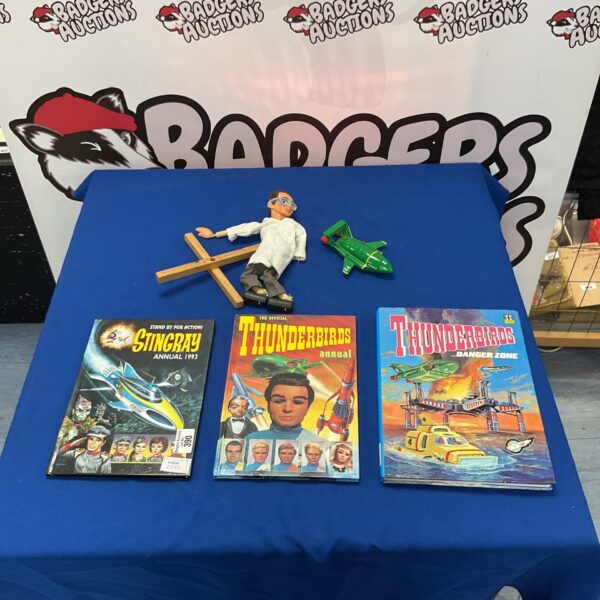 Vintage Thunderbirds and Stingray annuals with a model aircraft.