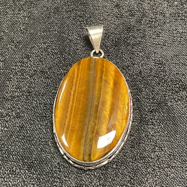 Close-up of a large oval tiger eye silver pendant.