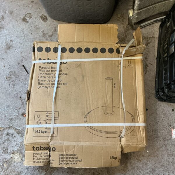 Metal Tobago parasol stand in original packaging for garden use.