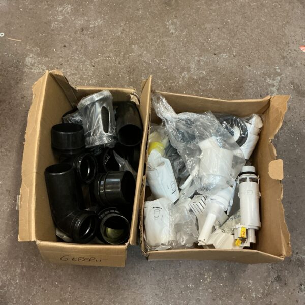 Assorted plastic toilet fitting pipes and connectors in a cardboard box.