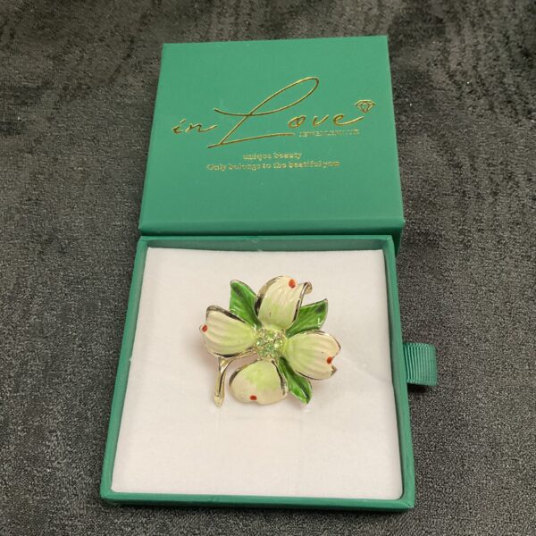 Vintage uranium glass flower brooch with white enamel details.