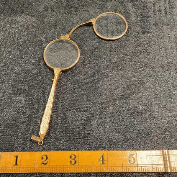 Close-up of antique Victorian lorgnettes with mother of pearl handle.