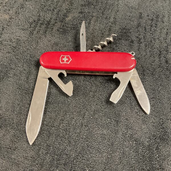 Red handled Victorinox Swiss Army Knife with multiple tools.