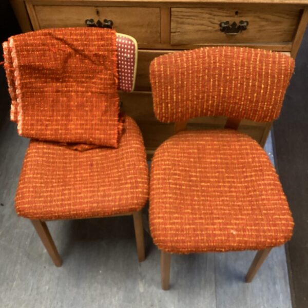 Two vintage orange Apersite chairs with wooden frames.