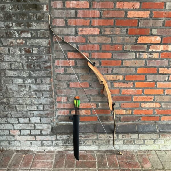 Vintage Armex Saxon recurve bow leaning against a brick wall.