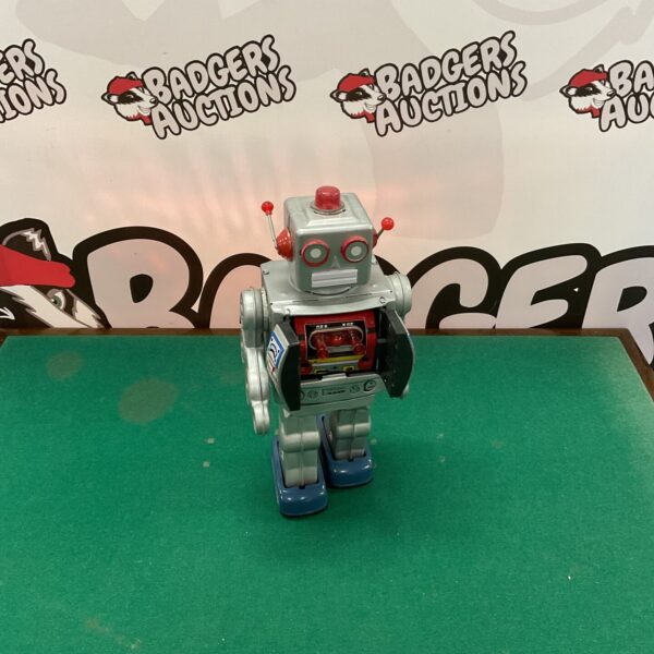 Vintage battery powered robot with illuminated eyes and articulated limbs.
