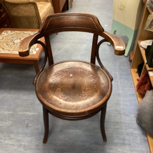 Vintage bentwood armchair with embossed detailing, antique furniture.