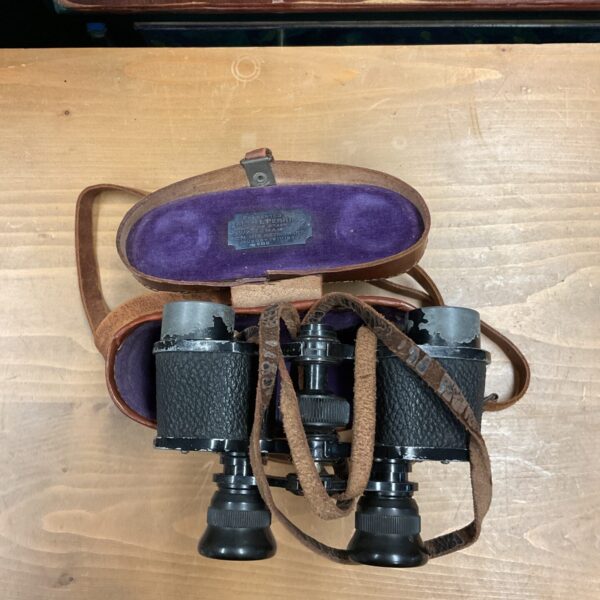 Vintage 1930s binoculars with a silver presentation plaque on the case.