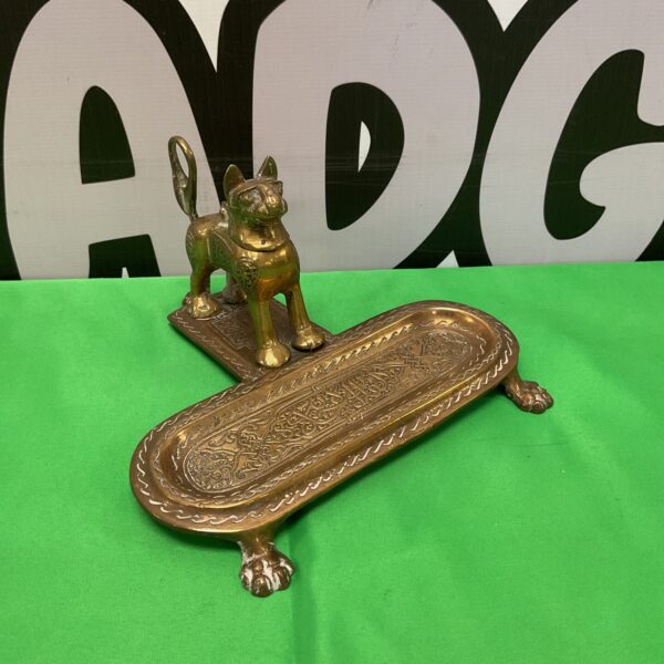Vintage brass cat inkwell with intricate Arabic design.