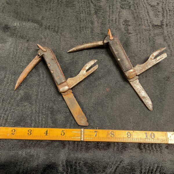 Vintage British Army jackknives on black background, WWII era.