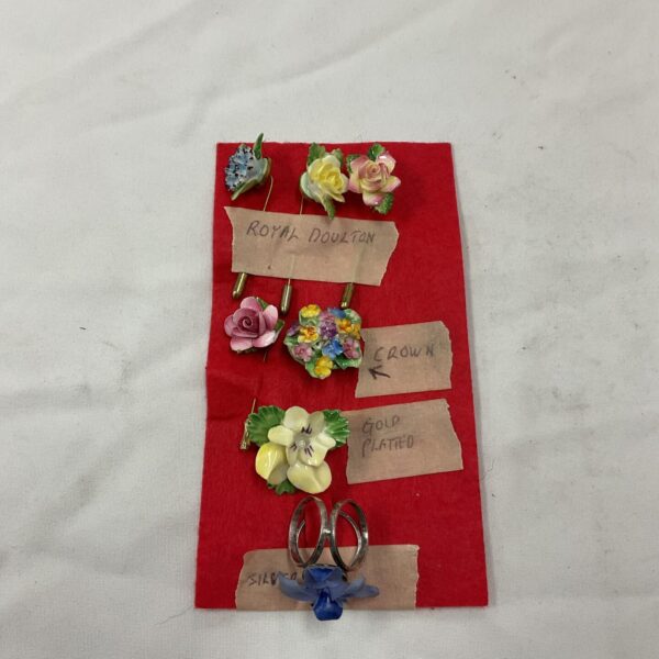 Vintage brooch collection featuring Royal Doulton and silver backed flower brooches.