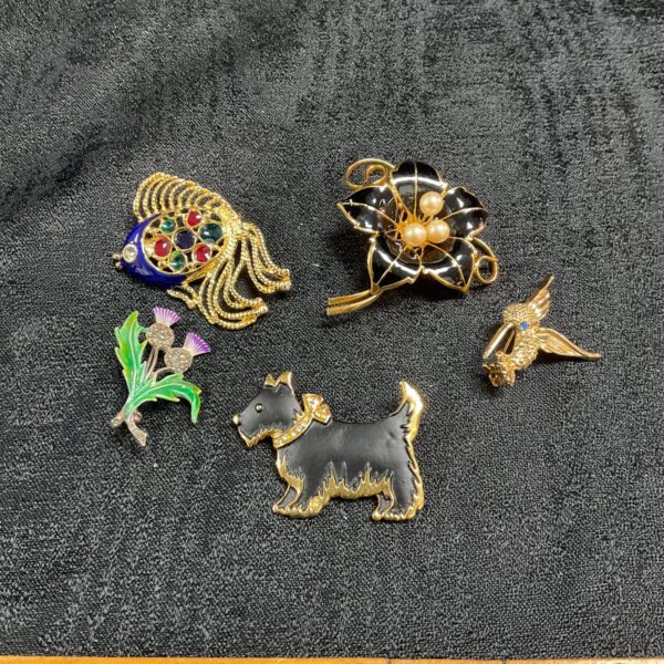 Vintage brooch lot featuring a Scottie dog and hummingbird pins.