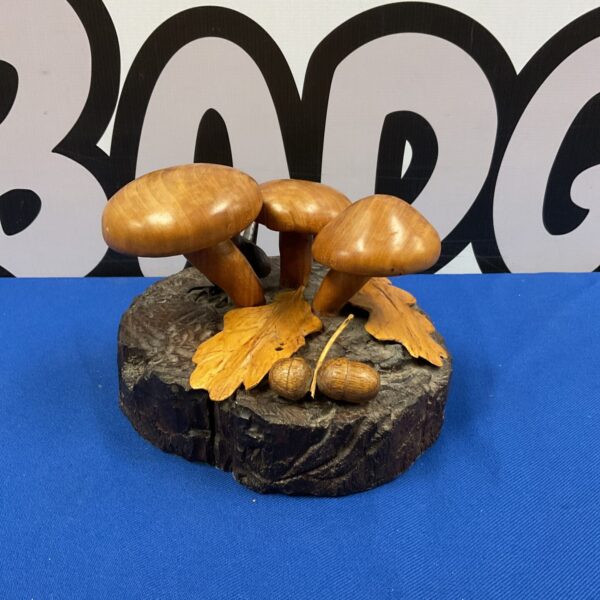 Detailed vintage carved mushroom sculpture on blue background.