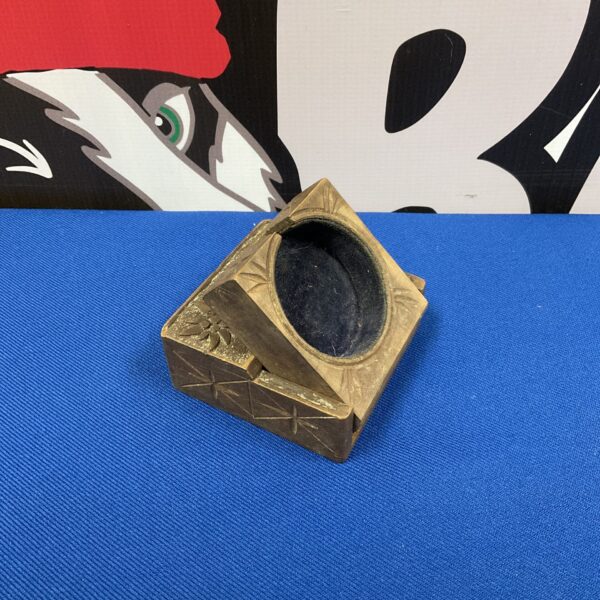 Vintage carved wooden pocket watch holder with dark interior.
