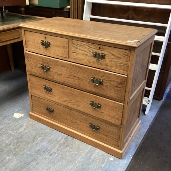 Vintage two-over-three chest of drawers with wood finish.