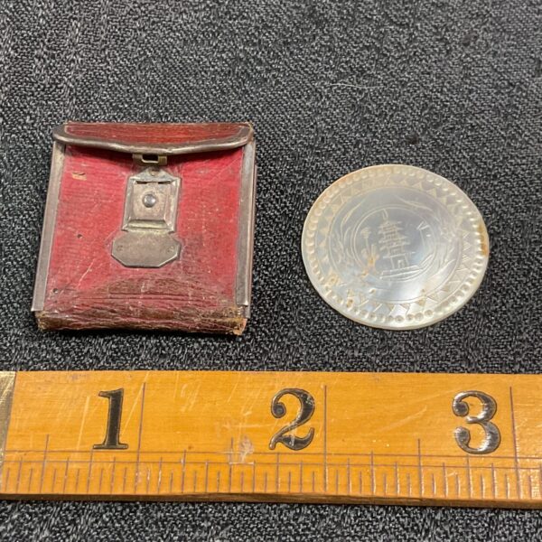 Vintage Chinese gaming token in red leather case with ruler.