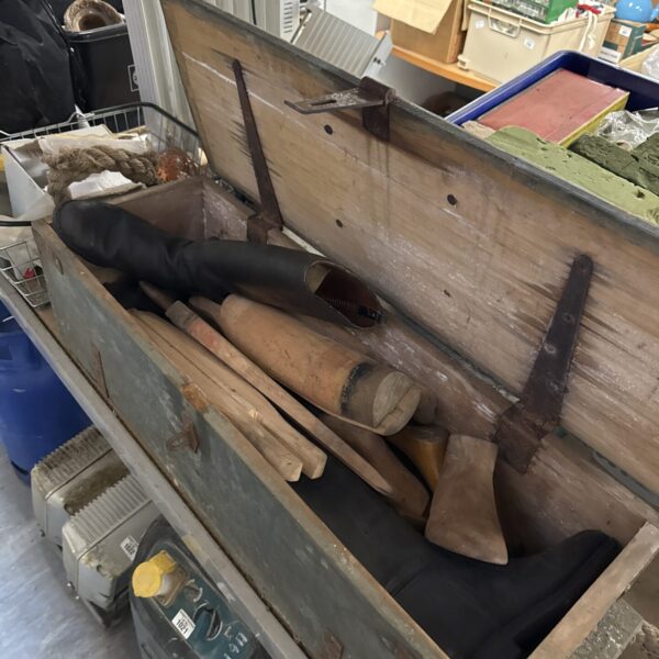 Vintage cobblers chest filled with antique shoe repair tools.