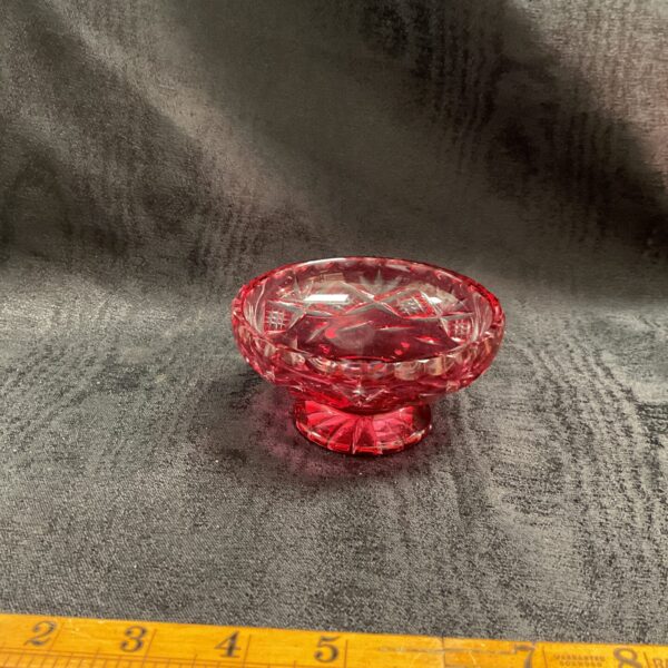 Vintage cranberry glass bowl with intricate cut glass design.
