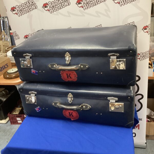 Two vintage globetrotter suitcases stacked, showing wear and age.
