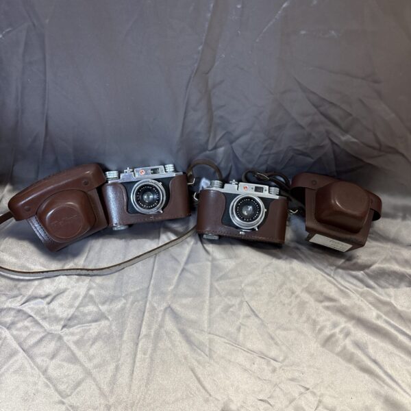 Vintage Halina camera pair in cases, collectible retro photography.