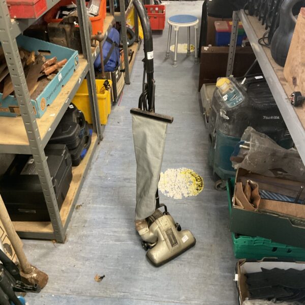 Vintage Hoover Junior vacuum cleaner in a home setting.