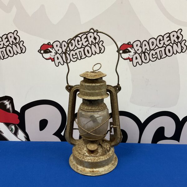 Vintage hurricane lantern with metal frame and glass globe.