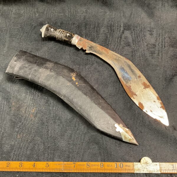 Vintage Indian khukri knife with curved blade and wooden handle.