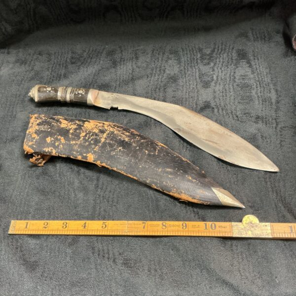 Vintage Indian kukri knife with leather sheath, traditional Gurkha weapon.