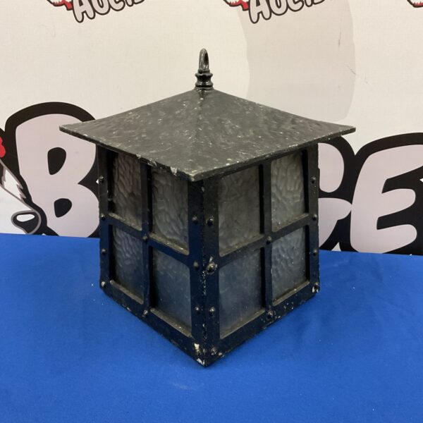Vintage iron hanging lantern with glass panels and ornate detailing.