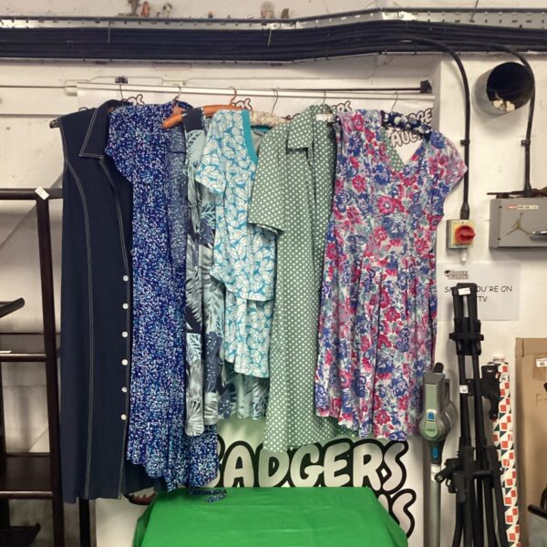 Mixed lot of vintage ladies dresses with floral and patterned designs.