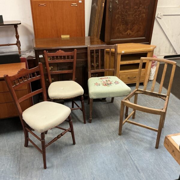 Vintage mahogany chairs with spindle backs, showing wear.