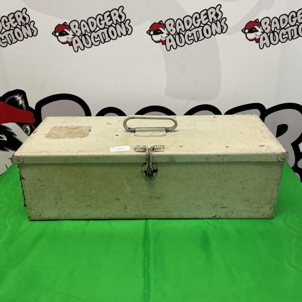 Front view of a vintage metal toolbox on a green background.