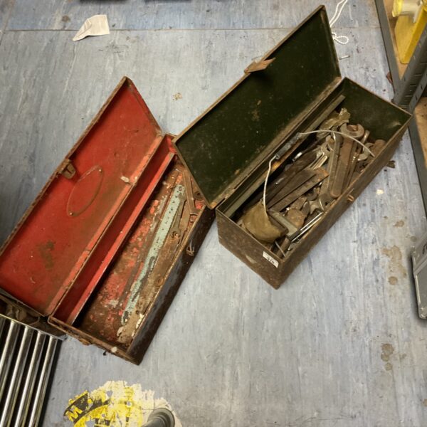 Vintage metal toolboxes with tools inside, antique workshop storage.