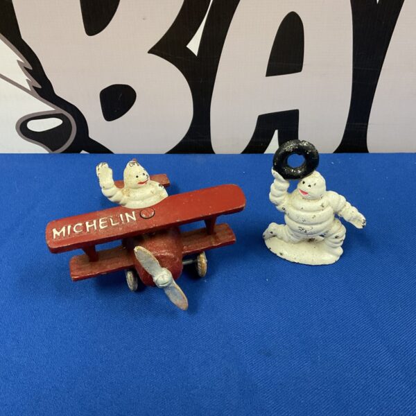 Vintage cast iron Michelin Man figure in a red biplane.