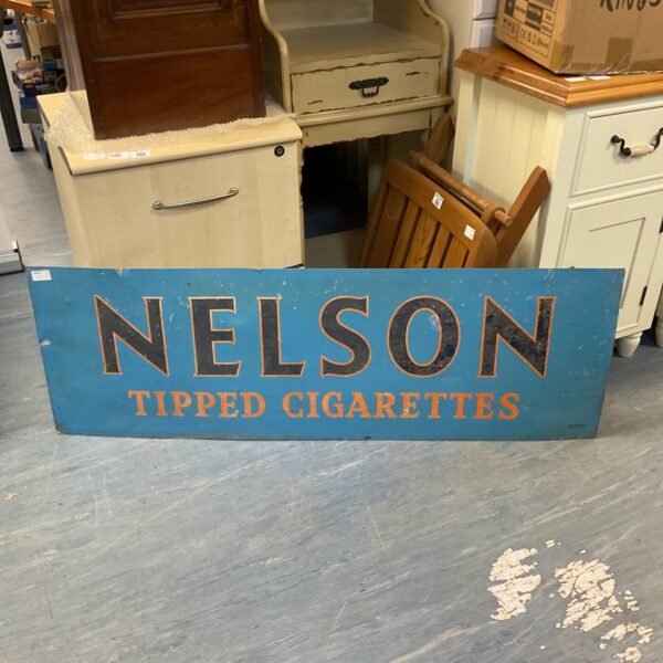 Vintage Nelson Tipped Cigarettes sign with bold lettering.